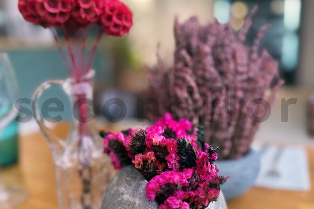 zoom sur des fleurs stabilisees fushsia dans la decoration des tables d'un hotel restaurant zoom on stabilised fushsia flowers to decorate tables in a hotel restaurant