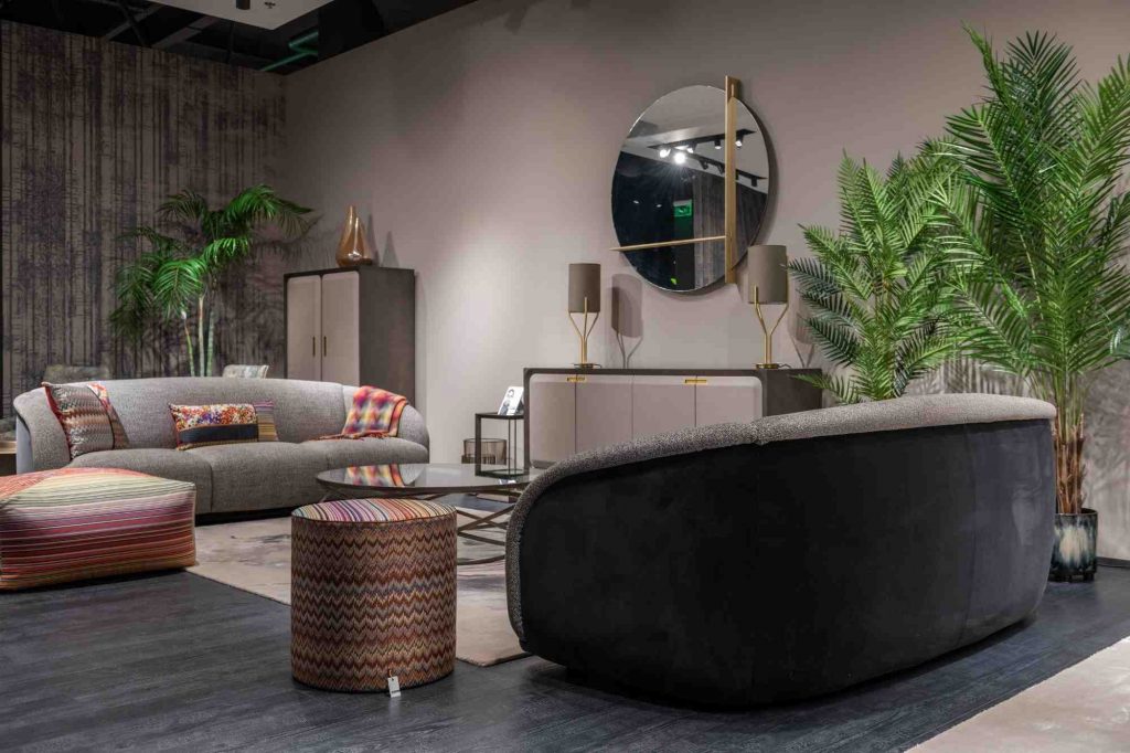 Séjour avec 2 canapés noir et gris et des murs mocha mousse ainsi que des plantes vertes mocha mousse pantone tred=nding colour 2025 couleur tendance 2025