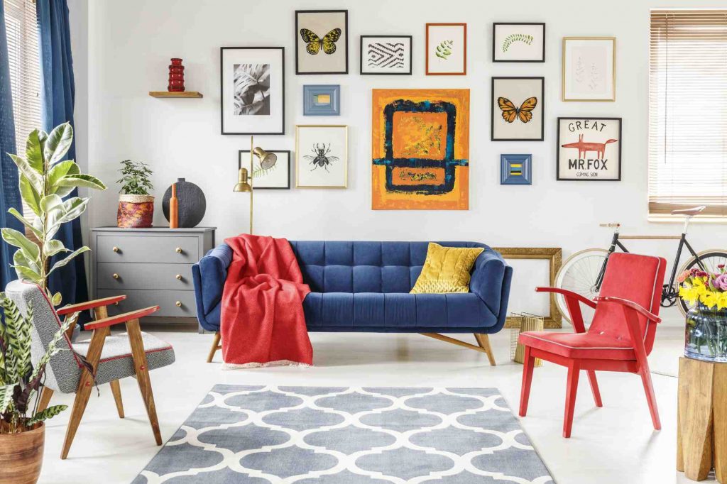 the unexpected red theory, element rouge dans une pièce neutre ici un salon blanc avec canapé bleu roi et plaid rouge